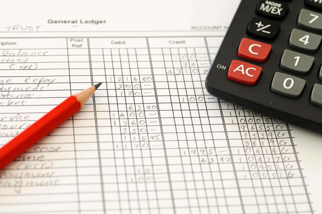 paper budgeting sheet with a pencil and calculator ontop